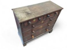 A stained oak chest of two short and three long dr