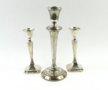 A pair of silver candlesticks, 15.5cm high (filled) and one other 22.5cm