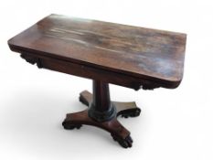 A mahogany foldable card table upon octagonal colu