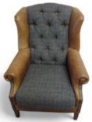 A wool and leather armchair with pinned support an