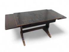 A dark Ercol dining table with oscillating T-shape
