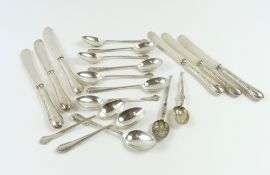 A small collection of silver flatware, including teaspoons, anointing spoons