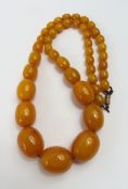 A row of graduated oval butterscotch amber beads,