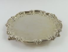 A small silver salver with floral and scrolled dec