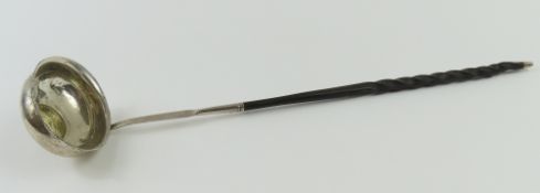 A silver toddy ladle with twisted handle and coin