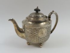 A silver teapot with chequered stripe-and-spot des