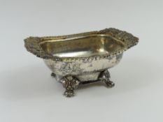 A Georgian silver salt pot with four floral feet a