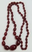 A graduated cherry amber oval bead necklace, the l