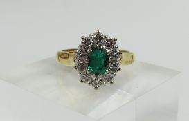 An 18ct gold emerald and diamond cluster ring, the