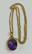 An oval facetted amethyst set into a simple decora