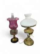 A decorative brass oil lamp with white glass shade