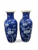 A pair of blue and white vases with flowering prun