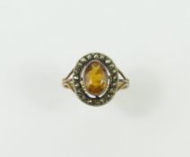 A synthetic orange sapphire and marcasite cluster