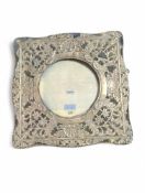 A photograph frame with silver floral, shell and t