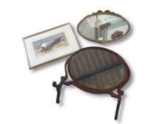 A standing swing mirror with oval frame, alongside