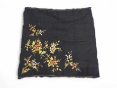 A panel of black fabric embroidered in colourful s