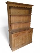 A modern pine dresser with two fixed shelves; belo
