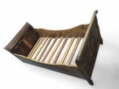 A stained-pine sleigh-style single bed