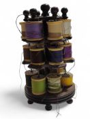 A three tier wooden cotton reel stand on ball supp