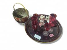 A large cranberry glass charger, tumblers and wine
