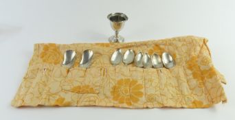 A Danish silver egg cup with a selection of silver and silver-plated spoons
