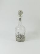 A round glass decanter with silver top and lower b