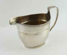 A silver milk jug of smooth oval form, with straig