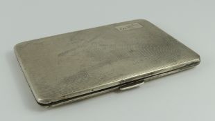 A silver engine-turned cigarette case