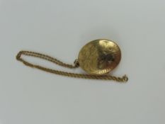 A large oval 9ct gold locket, with decorative engr