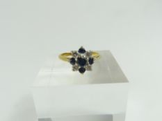 A sapphire and white stone cluster style ring, the