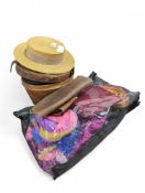 A straw boater, a black silk top hat in leather ca