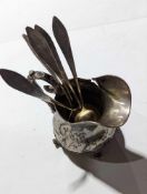 A short silver or silver-plated jug alongside five