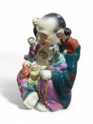A glazed pottery figure of seated Hotei with five