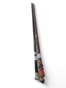 A naively carved wooden walking cane with a monkey