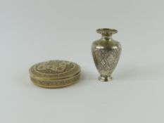 A small silver or silver-plated vase alongside a r