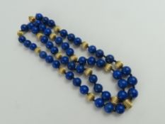 A row of polished lapis lazuli beads, with gold r