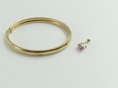 A 9ct gold hollow bangle, and a single amethyst st
