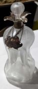A glass decanter with silver collar and three labe