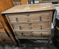 Oak chest of drawers comprising three long drawers, each with two brass handles and drop flap to