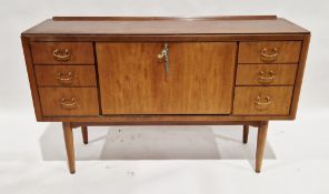 Mid-century teak sideboard with central fall-front storage cupboard flanked by three short drawers