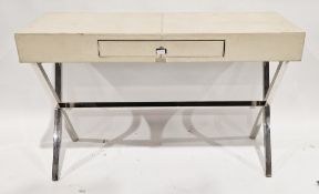 Modern cream faux leather covered desk with single drawer to the front, raised on chrome X-frame