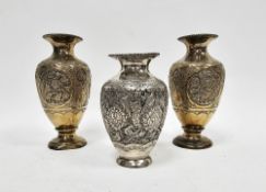Pair of Middle Eastern white metal gilt vases, each with embossed foliate motifs, 16cm high and a
