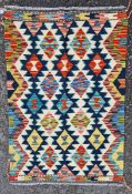 Chobi kilim, woven with a geometric medallion in red, blue and ochre reserved on a cream ground