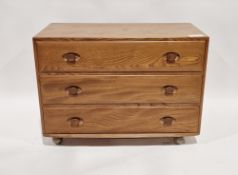 Ercol Windsor pattern blonde chest of three long drawers, raised on original castors, 67cm high x