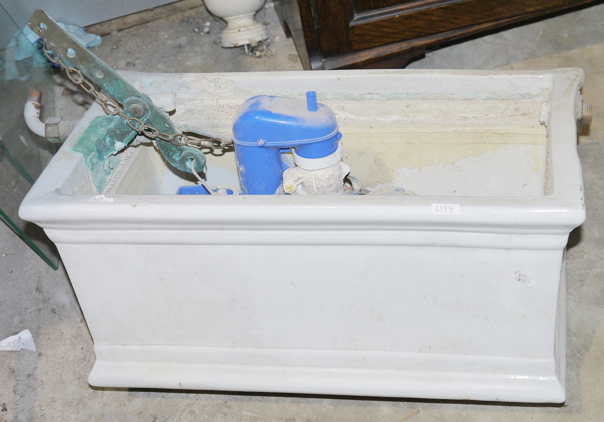 White ceramic toilet cistern  Condition Report Some small chips and some cracks.