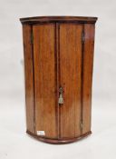 Georgian oak wall-hanging quarter round corner cupboard, the two doors opening to reveal three