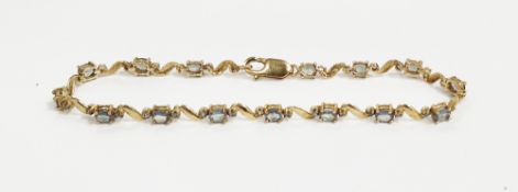 9ct gold and green stone bracelet, the green stones possibly Alexandrite, scroll design with oval