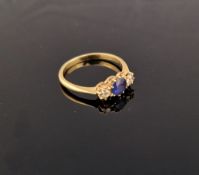 Gold-coloured metal, sapphire and diamond ring, the circular sapphire flanked by two diamonds, all
