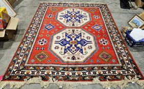 Russian red ground kazak carpet with two large central octagonal hooked medallions on geometric