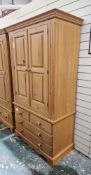 20th century pine two-door wardrobe, opening to reveal a removable clothes rail, over two short